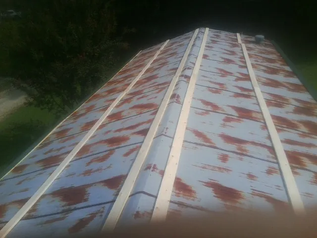 Rusted metal roof panels with new wood purlins before replacement — Storm Damage Roof Repair in Whitleyville by Roofing Brothers