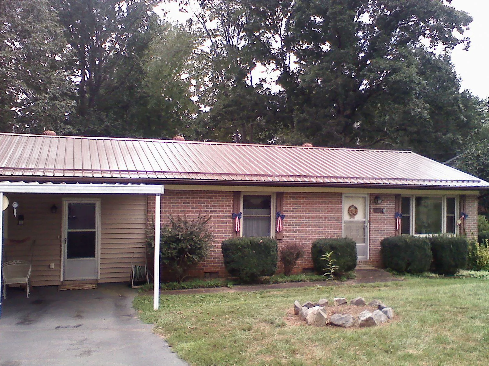 Bronze metal roof and carport on a brick ranch home — Roof Repair work by our crew in Whitleyville